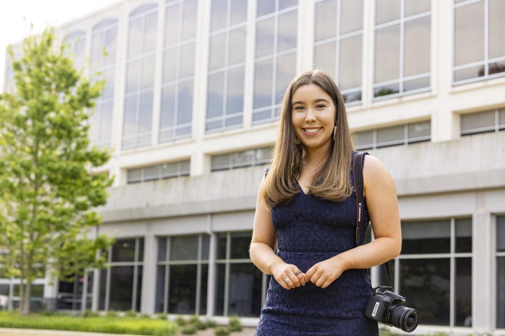 Kelly Krincek standing in front of the Journalism Building.