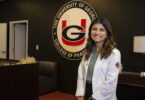 Portrait of Aliya Abdulla wearing a white pharmacist coat.